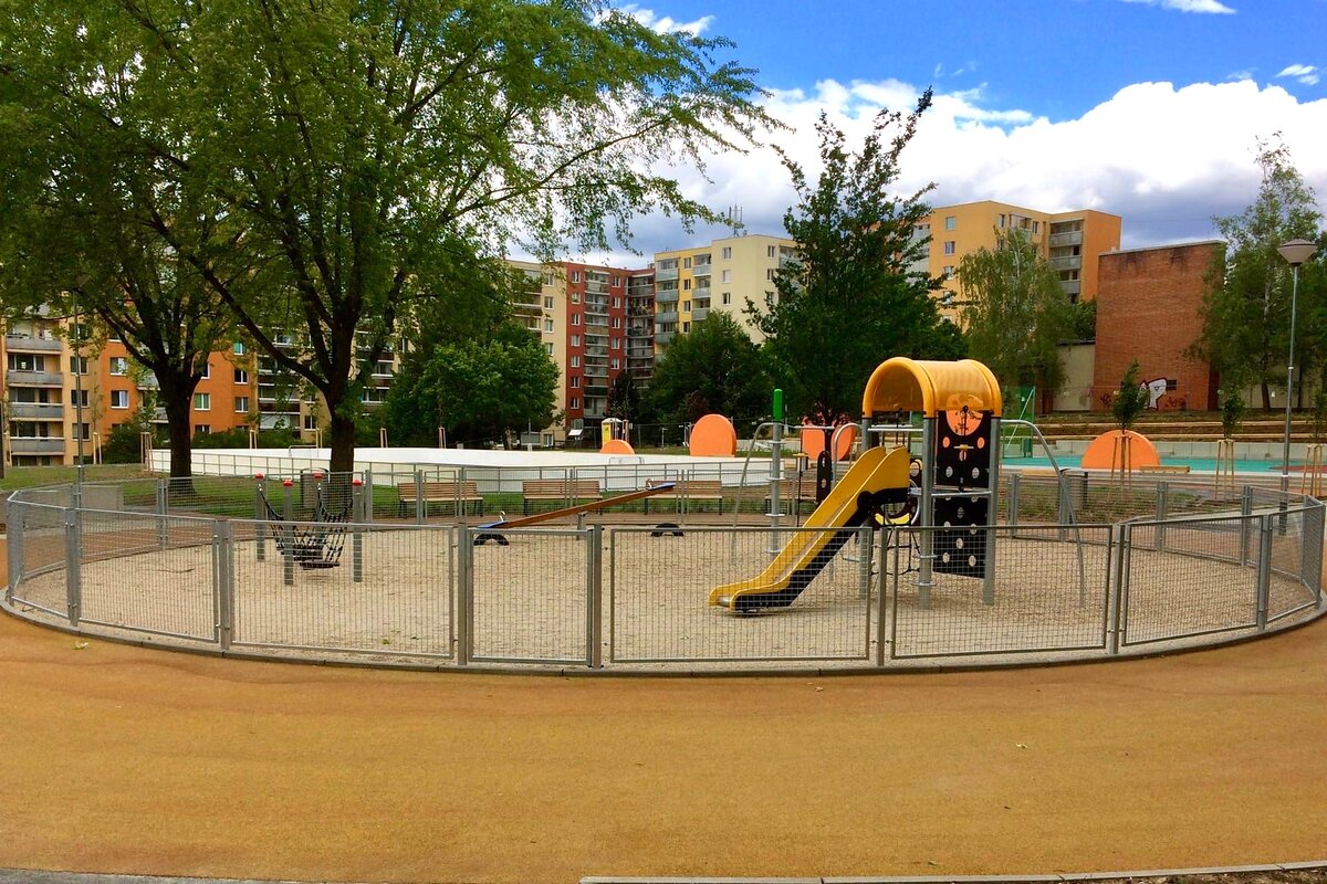 Oplocení dětského hřiště šedými panely na sídlišti