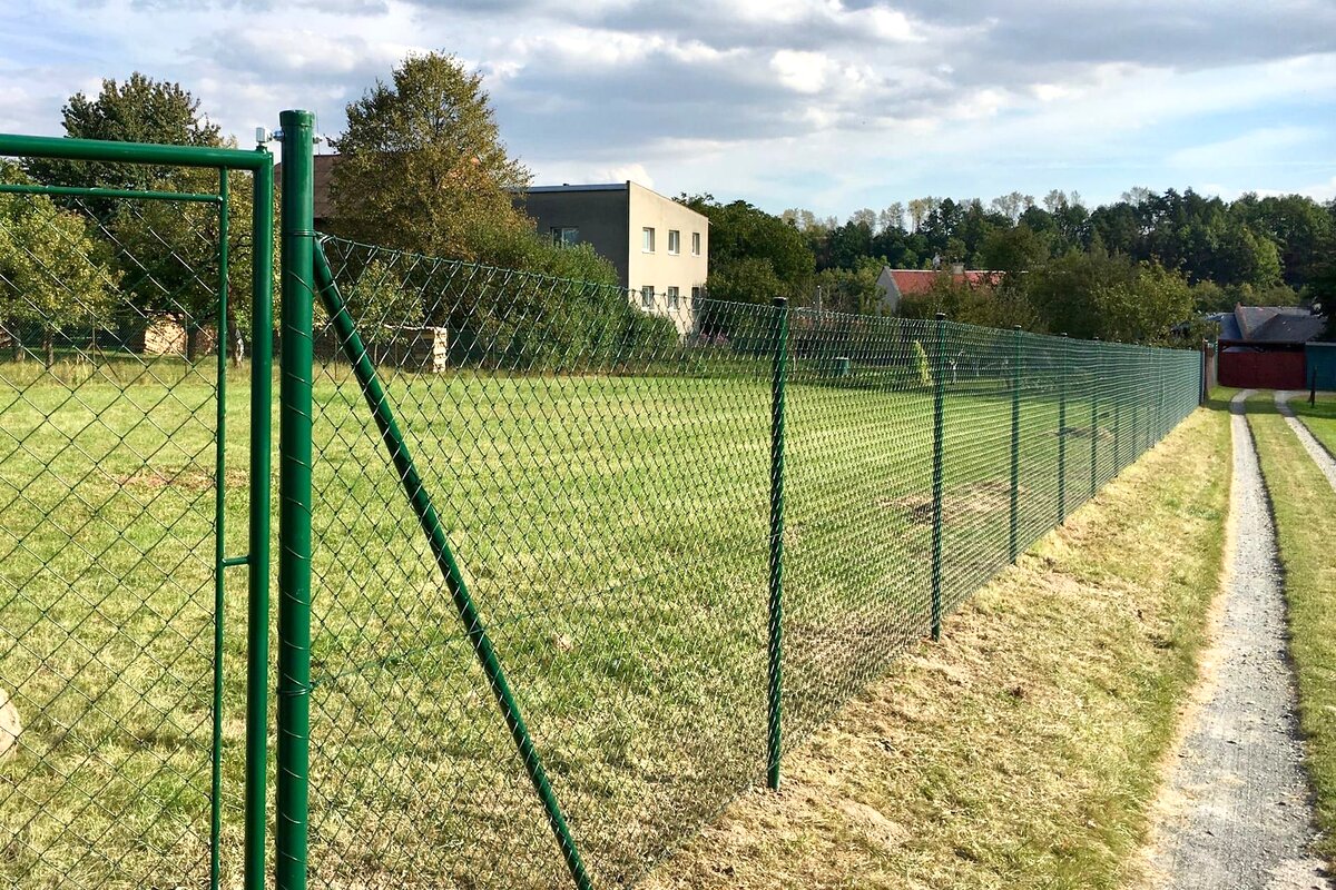 Zelený pletivový plot s brankou na venkově — realizace Stavíme ploty